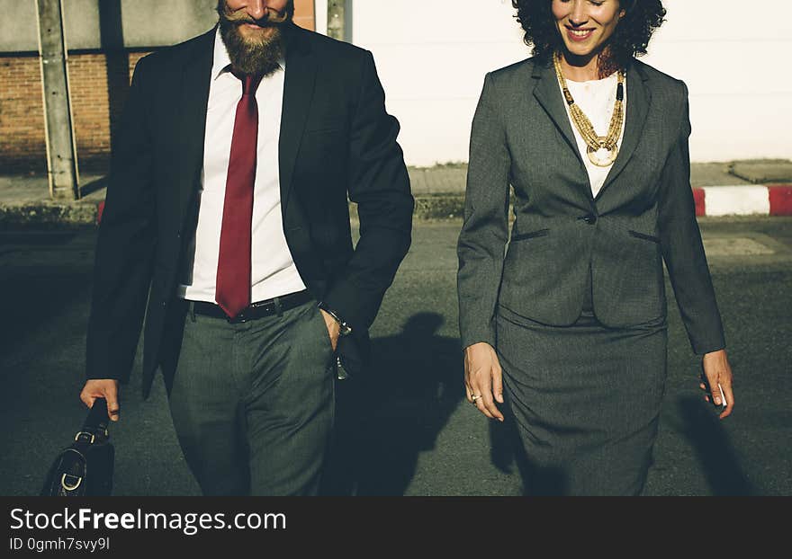 A couple in formal suits walking outdoors. A couple in formal suits walking outdoors.