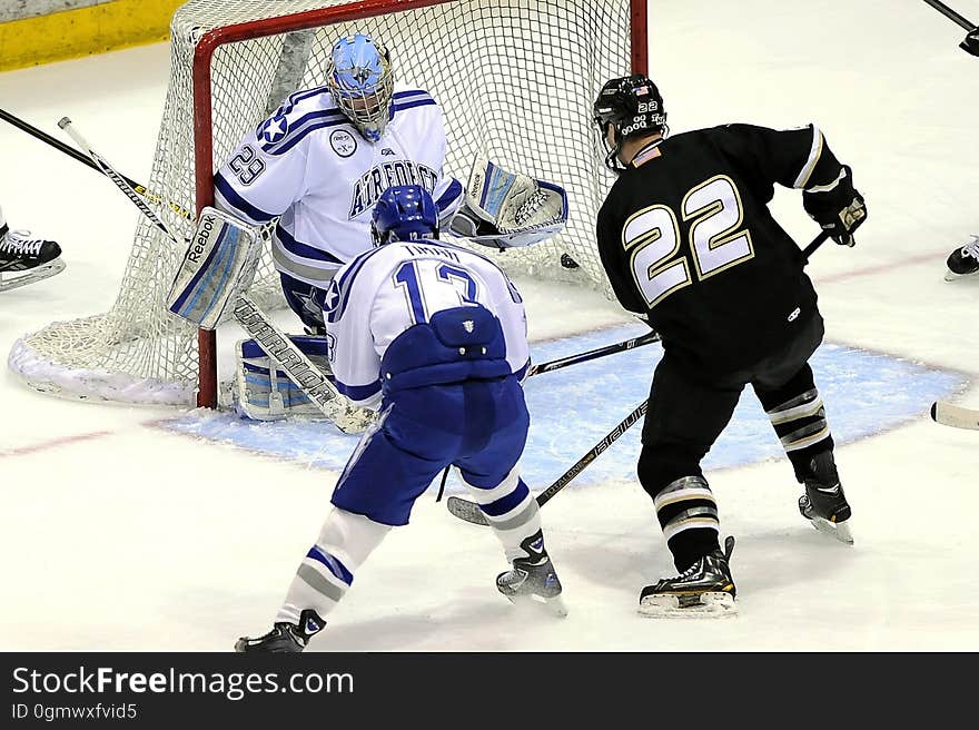 An ice hockey game with players fighting at the goal.