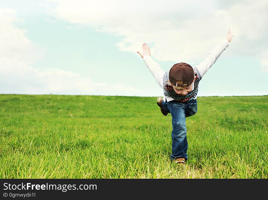 A kid running on green grass. A kid running on green grass.