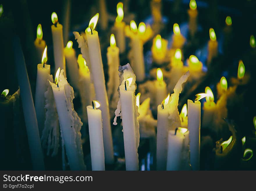 Candles lit at night, detail of an element of light, beliefs and faith, flame