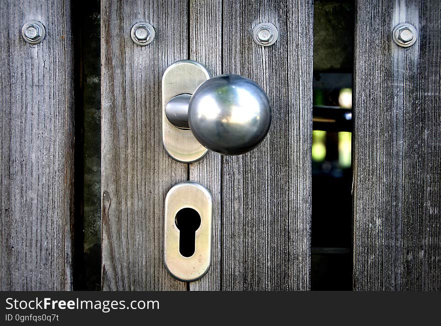 Closeup of a doorknob on a wooden door.