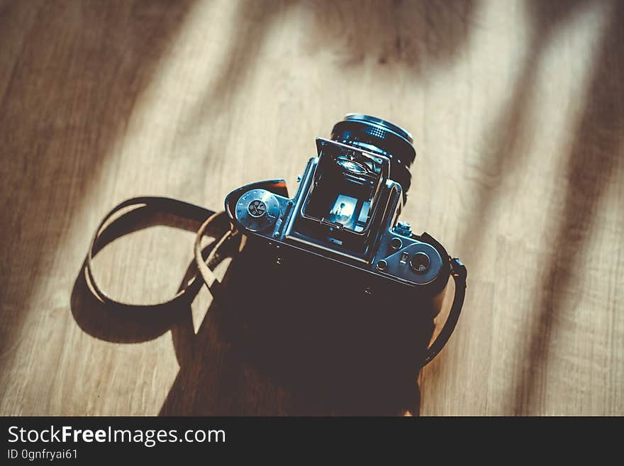 An above view of analog camera on a wooden background.