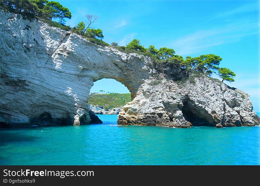 A rock formation with an entrance way in a bay. A rock formation with an entrance way in a bay.