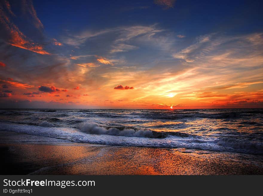 A beautiful beach sunset with waves crashing on the shore.