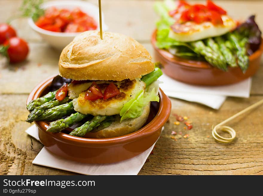 Sandwiches with grilled asparagus and goat cheese in small clay ramekins.