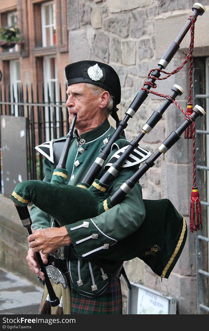 An elderly man plays the bagpipes. An elderly man plays the bagpipes.