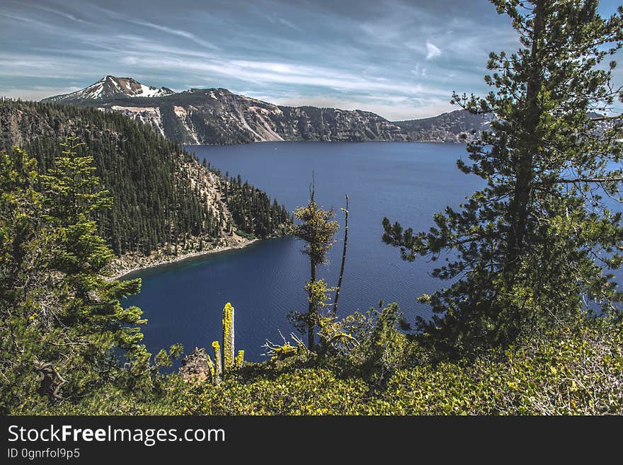 A lake with mountains on the shores and coniferous forests. A lake with mountains on the shores and coniferous forests.