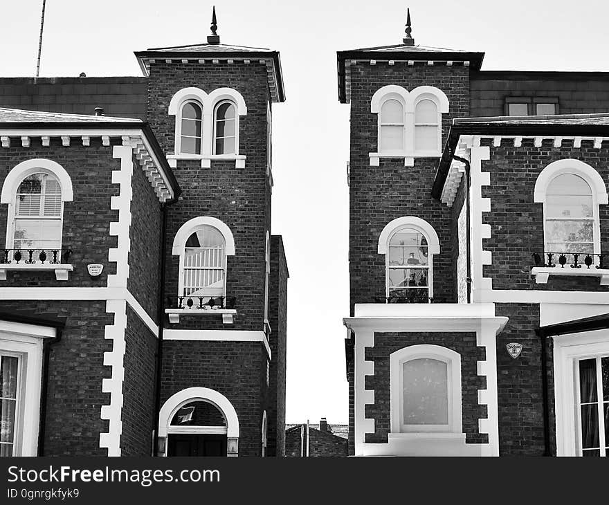 Exterior of brick houses with windows and spire in black and white. Exterior of brick houses with windows and spire in black and white.