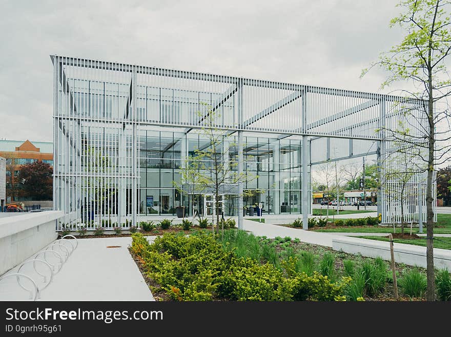 Exterior of glass and steel modern building with landscaping on sunny day.