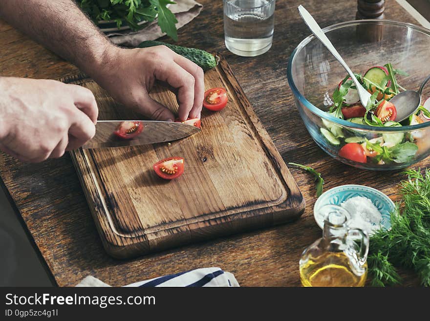 Healthy food concept. Man preparing breakfast from salad in home kitchen