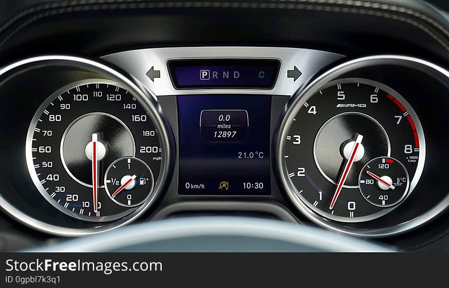 A close up of an odometer and a speedometer on a dashboard. A close up of an odometer and a speedometer on a dashboard.