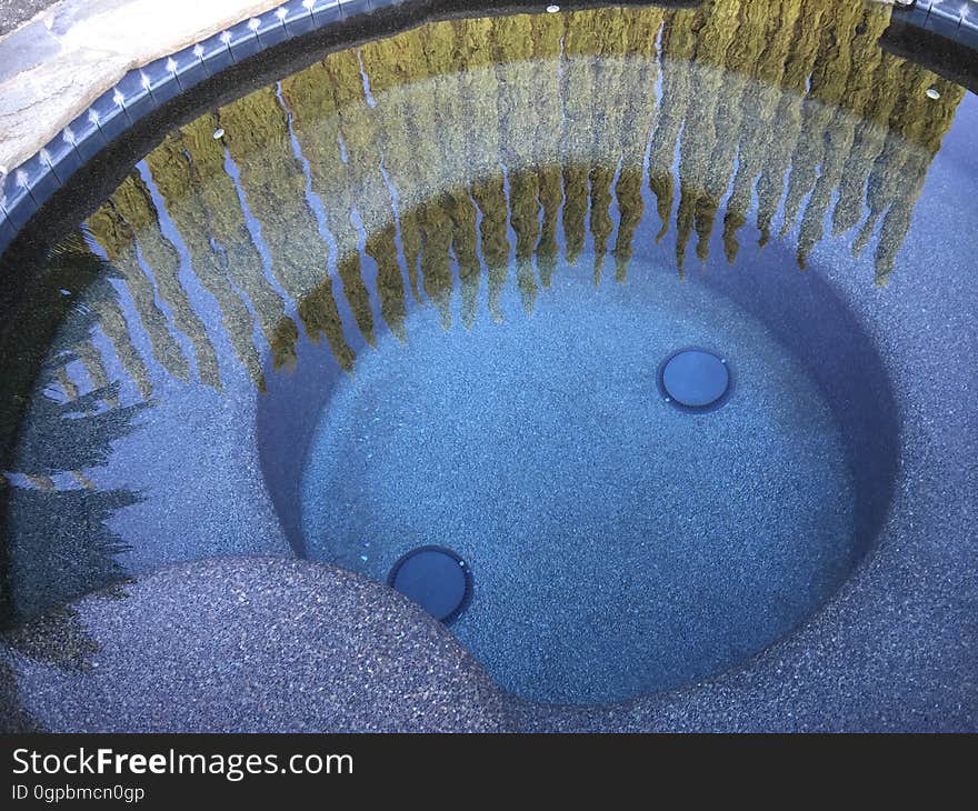 Stone pool with reflection of green bushes on sunny day. Stone pool with reflection of green bushes on sunny day.