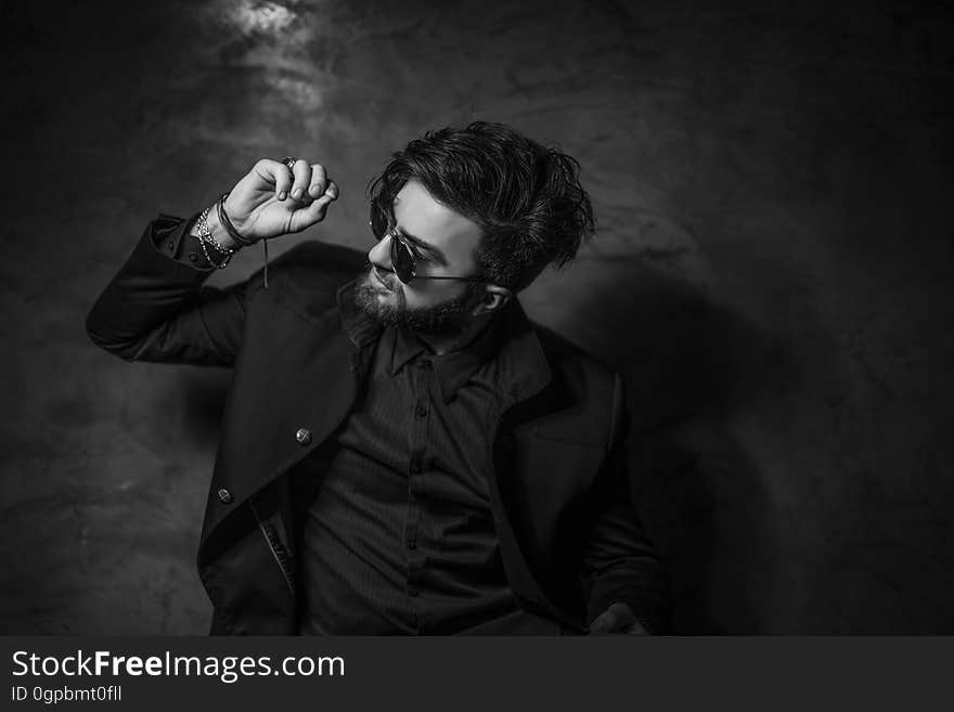 Man wearing sunglasses dancing in studio portrait in black and white. Man wearing sunglasses dancing in studio portrait in black and white.