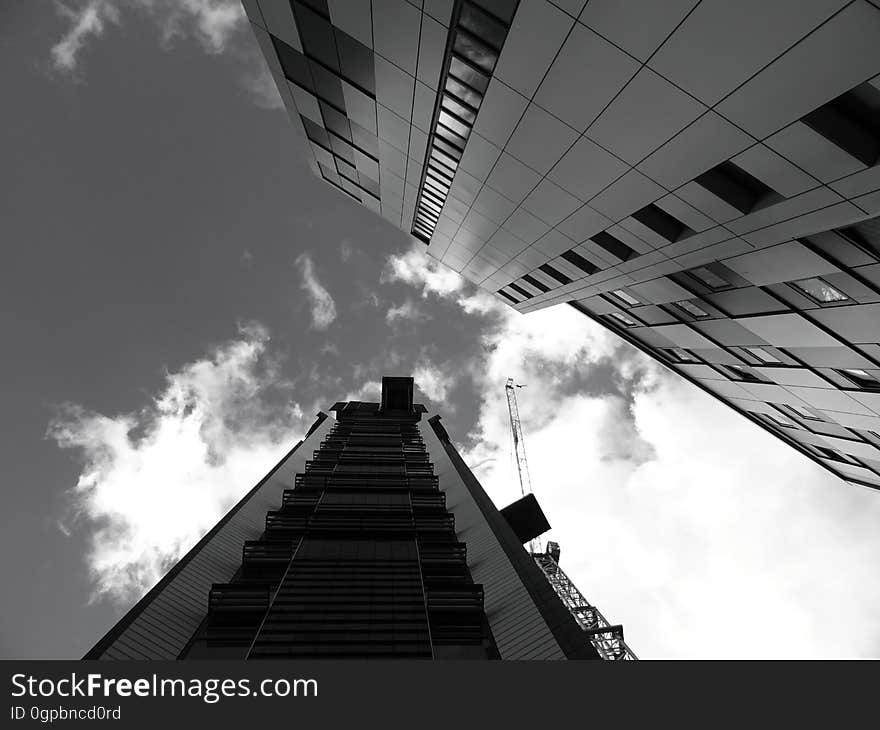 A low-angle view of buildings in a city in black and white. A low-angle view of buildings in a city in black and white.