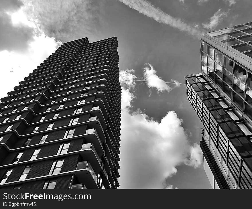 A low-angle view of city skyscrapers in black and white. A low-angle view of city skyscrapers in black and white.