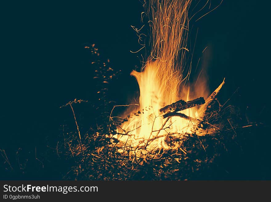 A close up of a bonfire sparkling in the dark.