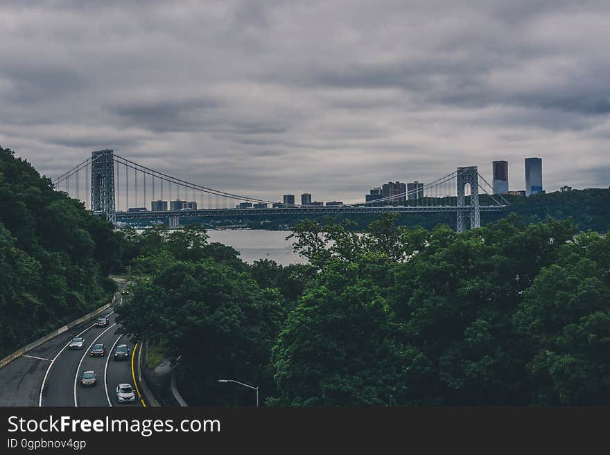 A cityscape on a gloomy day with a freeway connecting to a bridge. A cityscape on a gloomy day with a freeway connecting to a bridge.