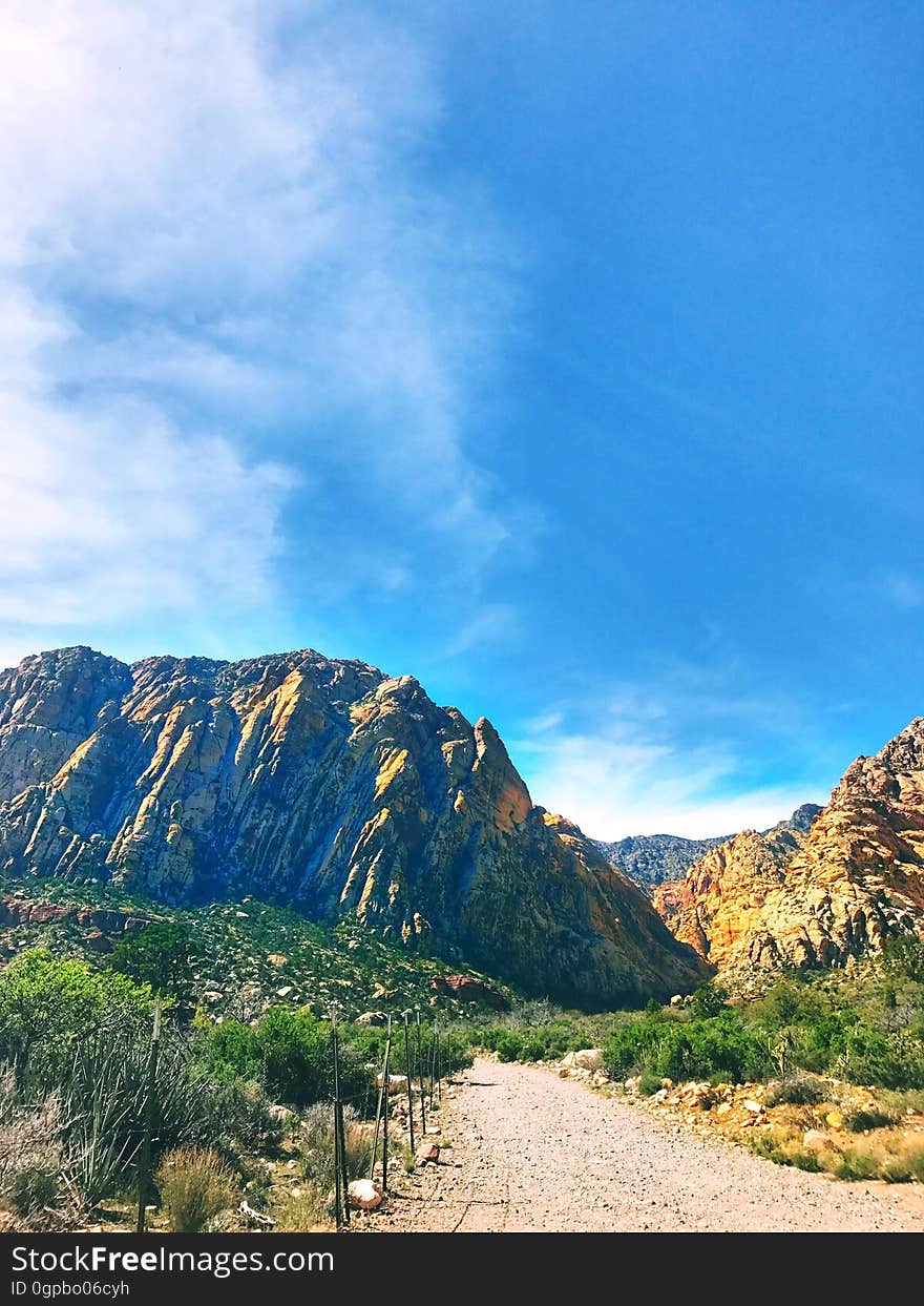 A dirt road leading to mountains.