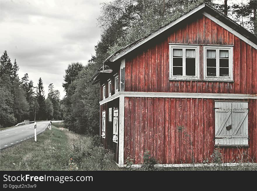 A rustic barn next to an empty road.