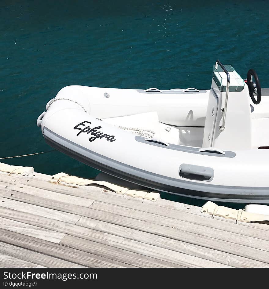 A watercraft stationed next to a dock. A watercraft stationed next to a dock.