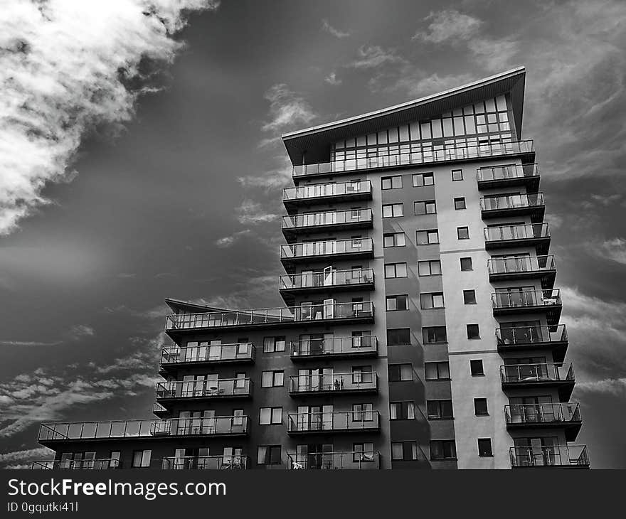 Facade of high rise apartment building against cloudy skies in black and white. Facade of high rise apartment building against cloudy skies in black and white.