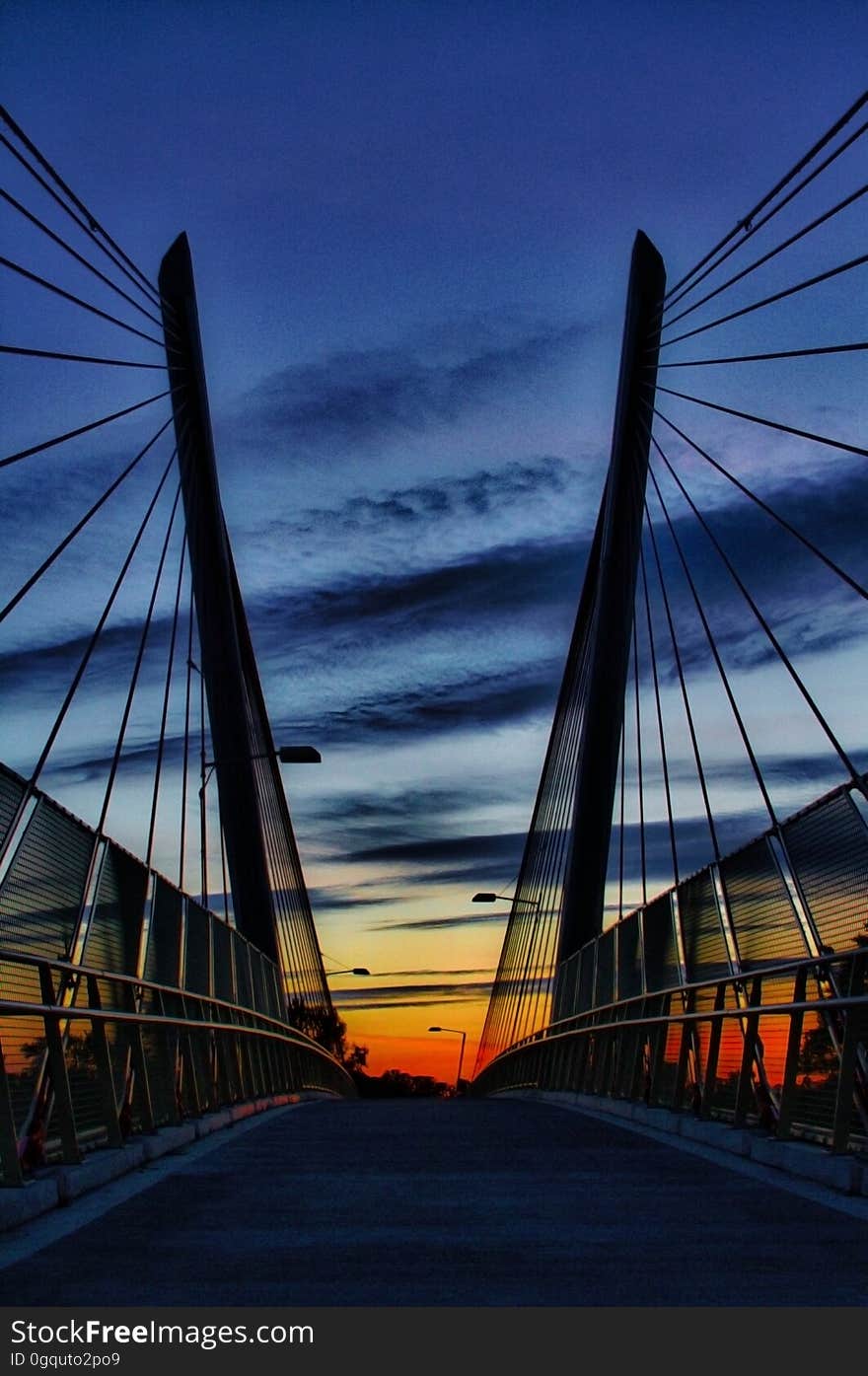 Sunset over empty suspension bridge on roadway. Sunset over empty suspension bridge on roadway.