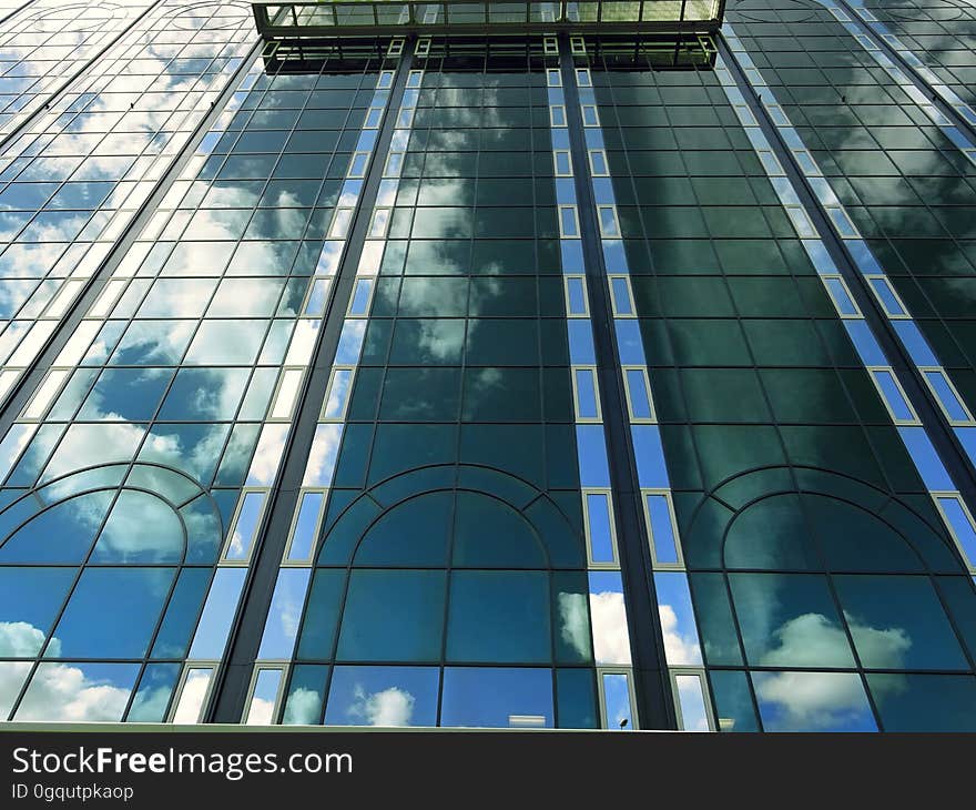 Blue skies and clouds reflecting in front of glass and steel modern building. Blue skies and clouds reflecting in front of glass and steel modern building.