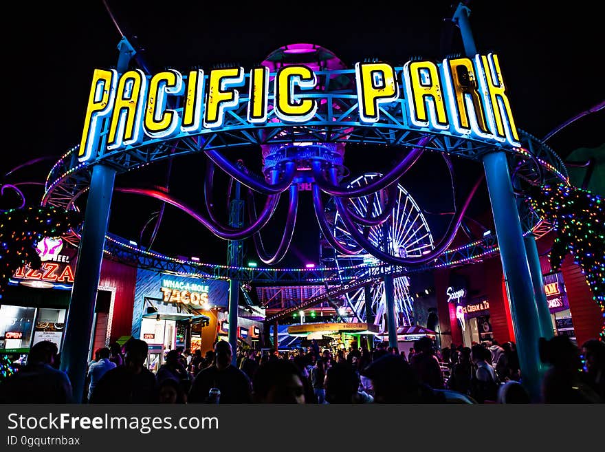 A crowd of people at an amusement park at night. A crowd of people at an amusement park at night.