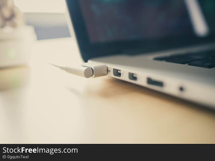 A close up of a cable plugged into a laptop. A close up of a cable plugged into a laptop.