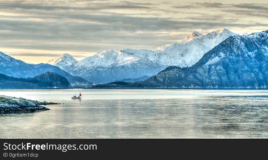 A person boating through fjords on a wintry day.