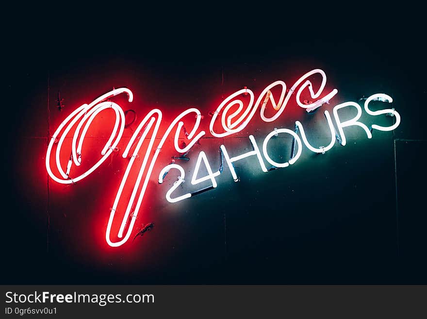 A neon sign with the text "Open 24 hours".