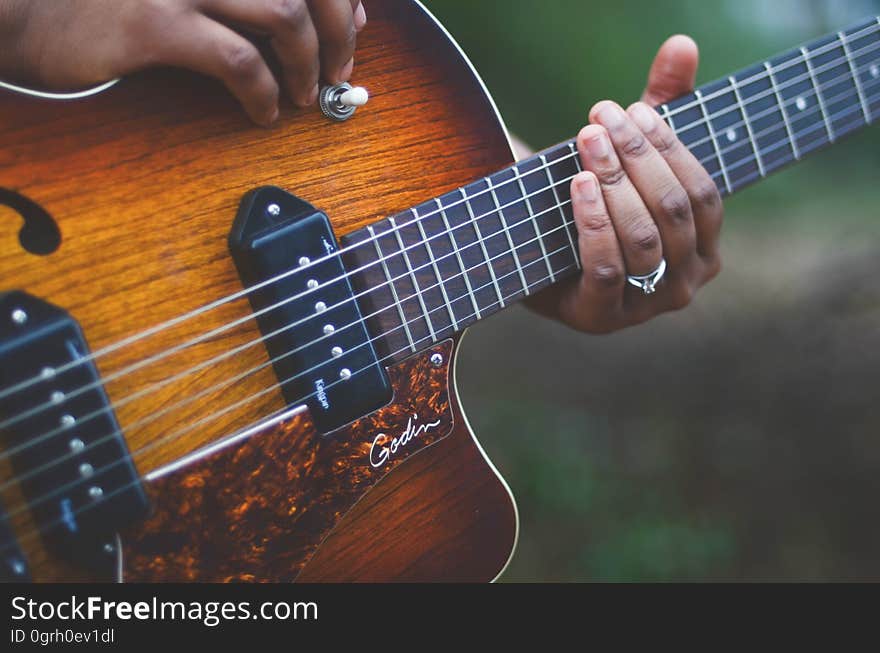 Person Holding Brown and Black Electric Guitar