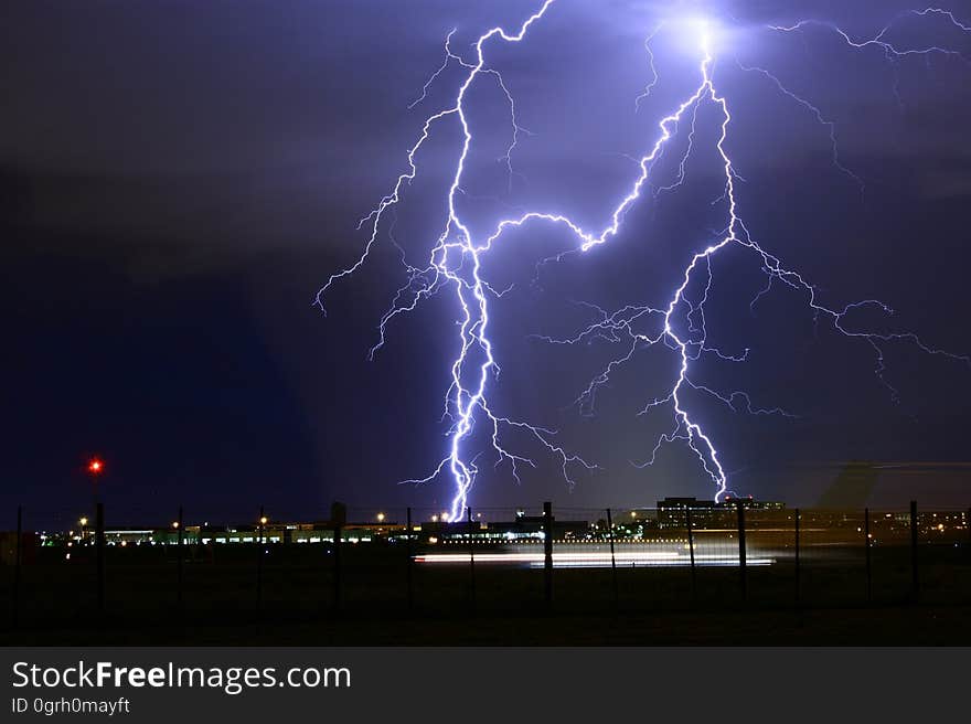 A city at night with lightning striking from the sky. A city at night with lightning striking from the sky.