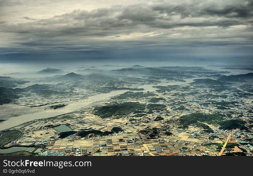 Aerial View Photo of Urban Area and Mountain Range in the Distance Under Gray Cloudy Sky