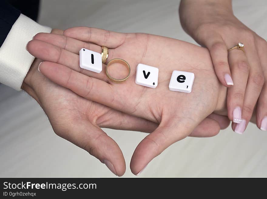 The hands of a couple with the word "love" written on with letter tiles. The hands of a couple with the word "love" written on with letter tiles.