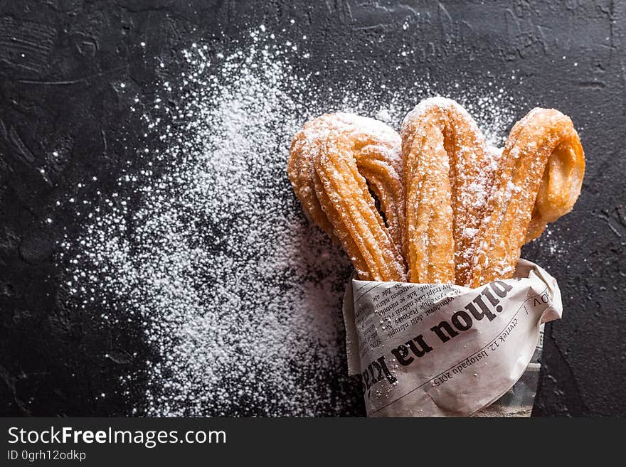 Closeup of churros dusted with powdered sugar.