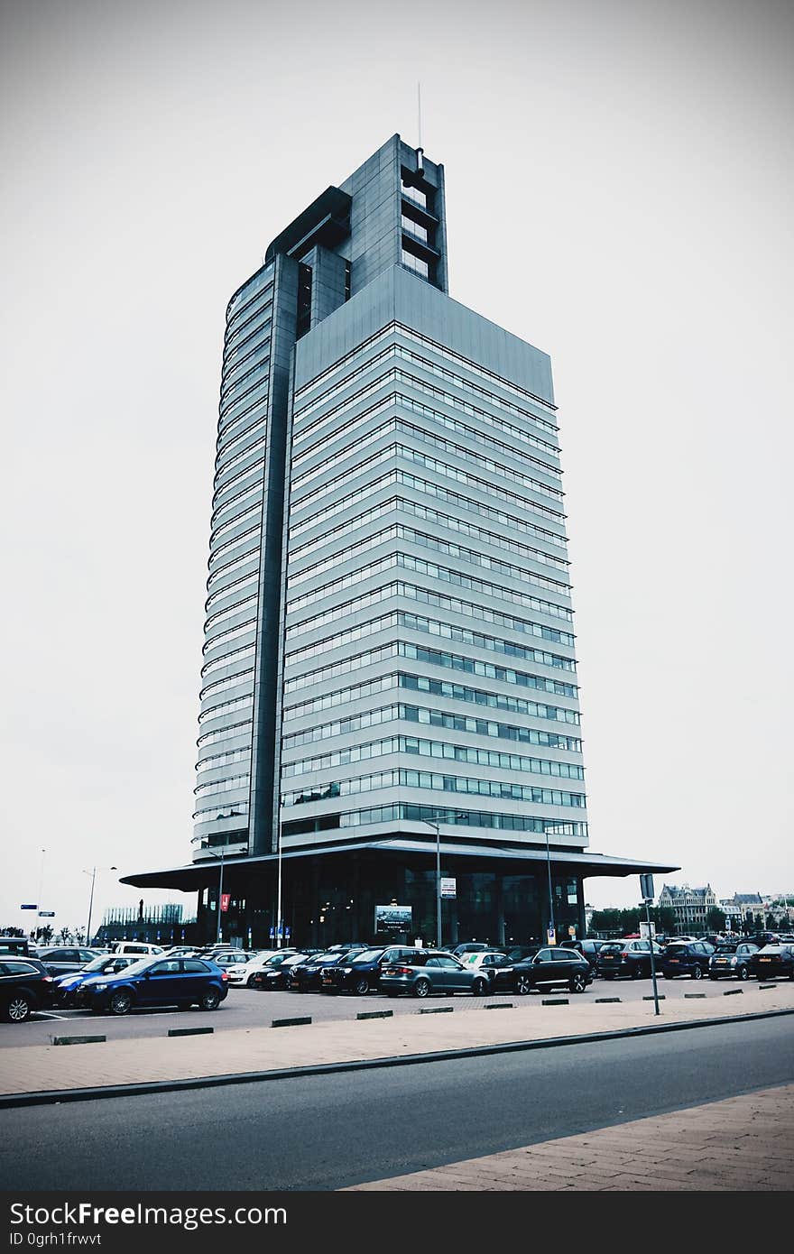 A modern high-rise building with a parking lot. A modern high-rise building with a parking lot.