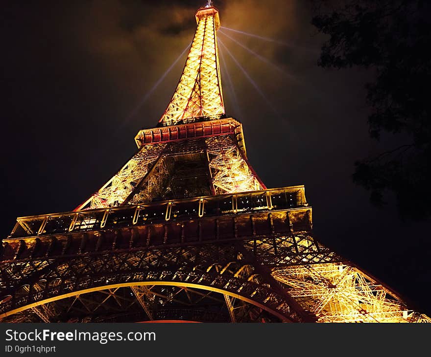 The Eiffel tower with the lights on at night. The Eiffel tower with the lights on at night.