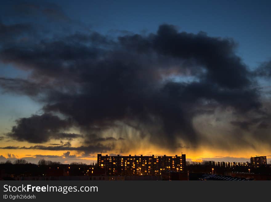 Lighted High Rise Building Under Blue Clouding Sky during Sunset