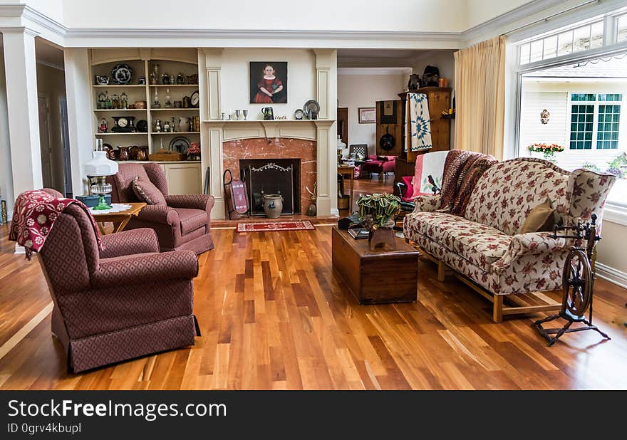 Attractive sitting room (lounge) furnished with beige patterned sofa and purple arm chairs (with wings), polished wooden floor and fireplace with safety screen. Attractive sitting room (lounge) furnished with beige patterned sofa and purple arm chairs (with wings), polished wooden floor and fireplace with safety screen.