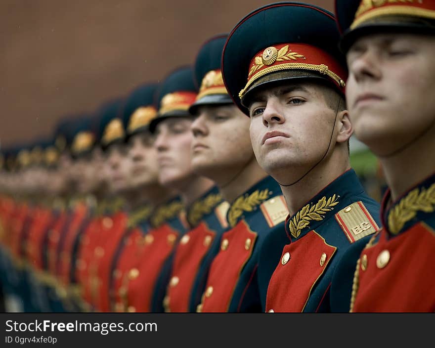 Men in Black and Red Cade Hats and Military Uniform