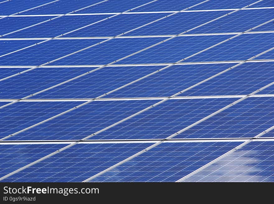 A solar panel array with the sky reflecting from it. A solar panel array with the sky reflecting from it.