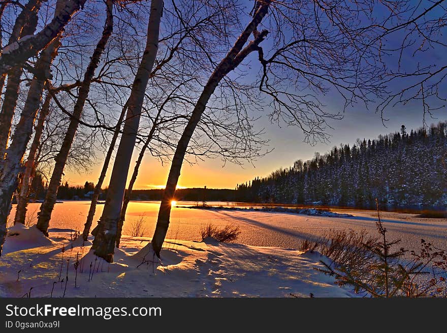 A winter morning sunrise over snowy fields or lakes.