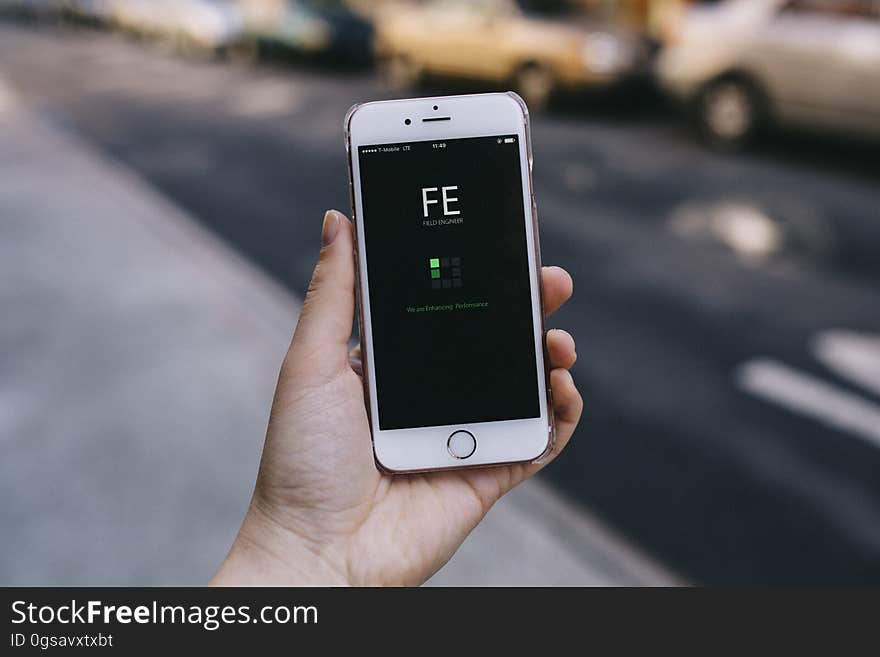 A person holding a mobile phone displaying an app.