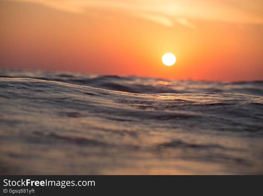 Sunset in orange skies over ocean waves. Sunset in orange skies over ocean waves.