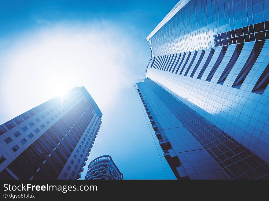 Abstract background created by skyscrapers of ultramodern architectural design and viewed upwards and into bright sunlight. Abstract background created by skyscrapers of ultramodern architectural design and viewed upwards and into bright sunlight.