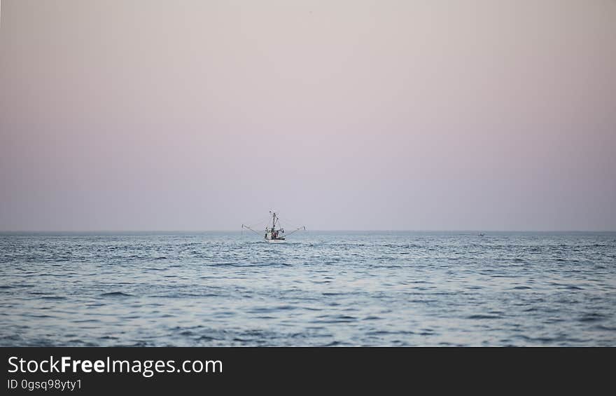 Fishing boat on ocean waves a sunset. Fishing boat on ocean waves a sunset.