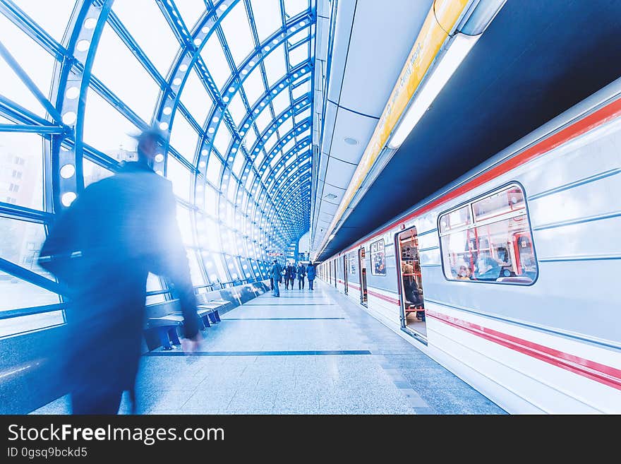 Commuters on platform in modern station next to train. Commuters on platform in modern station next to train.