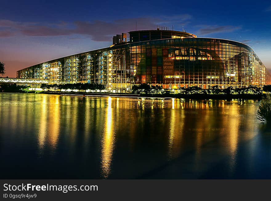 Illuminated building on waterfront of Strasbourg, Austria at night reflecting in river. Illuminated building on waterfront of Strasbourg, Austria at night reflecting in river.