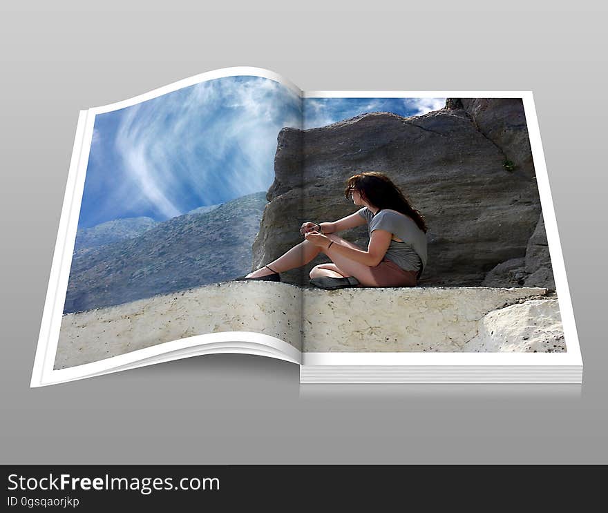 Woman in Gray Shirt Sitting over Brown Formation of Rock during Daytime Book